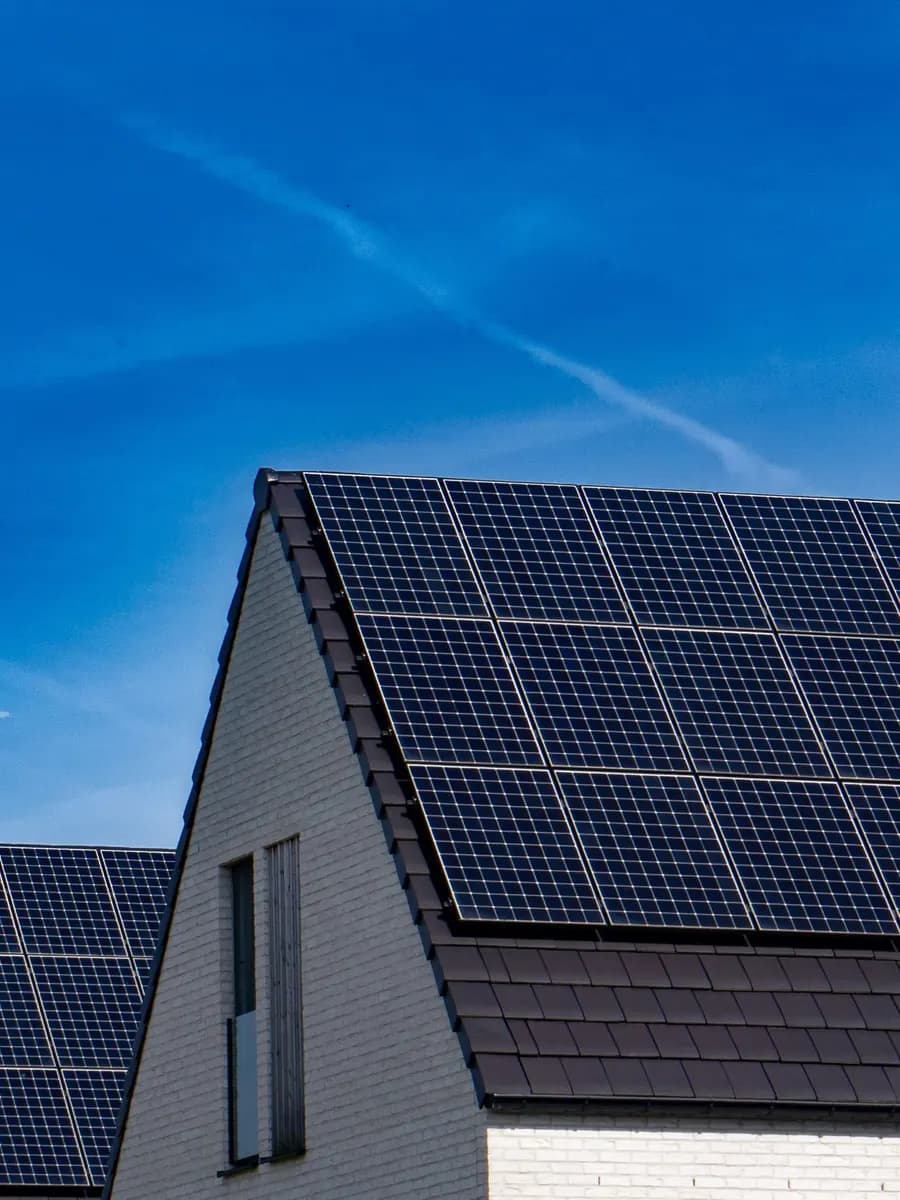 Pitched house roofs covered with solar panels under a clear blue sky