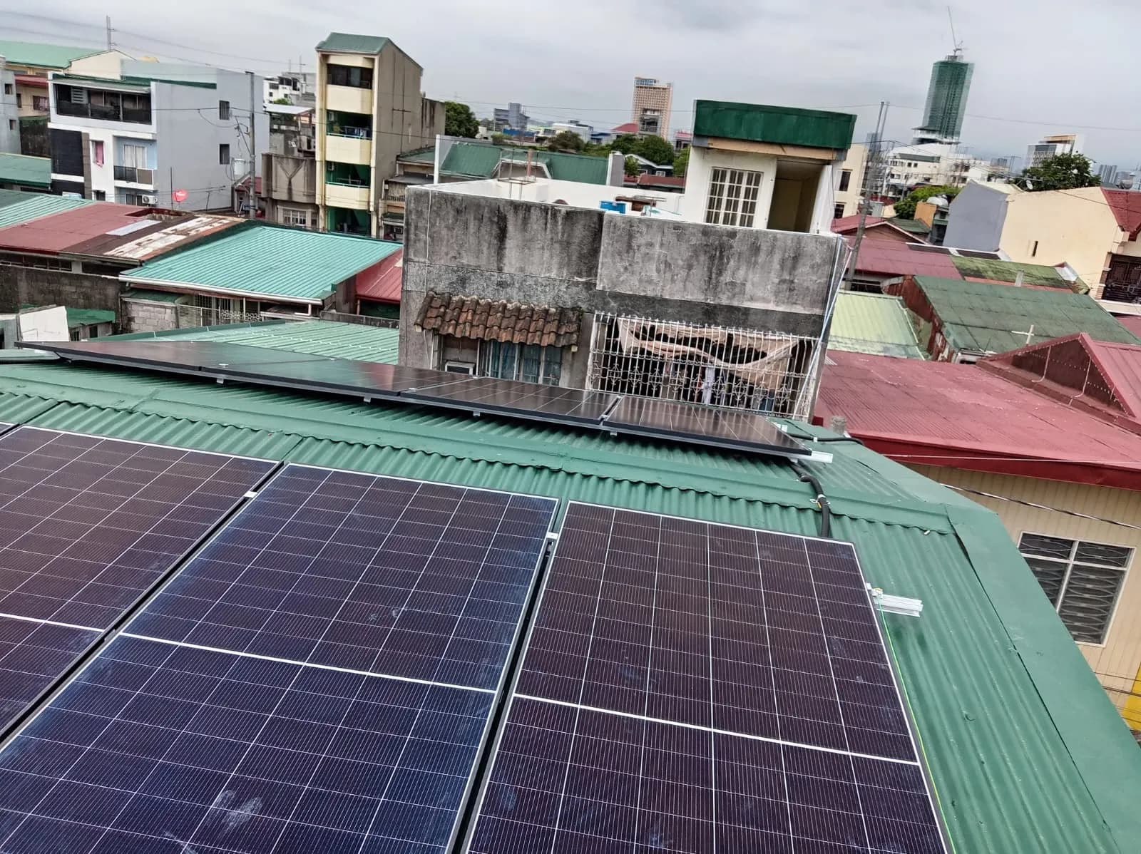 Rooftop solar array installed across a green metal roof