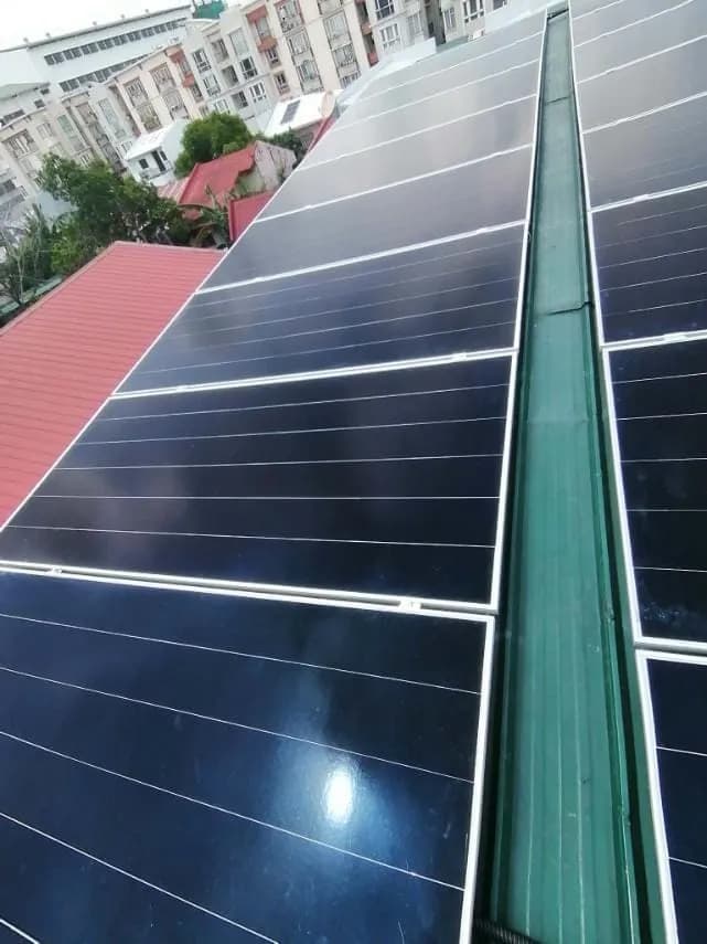 Two rows of solar panels mounted along a roof ridge